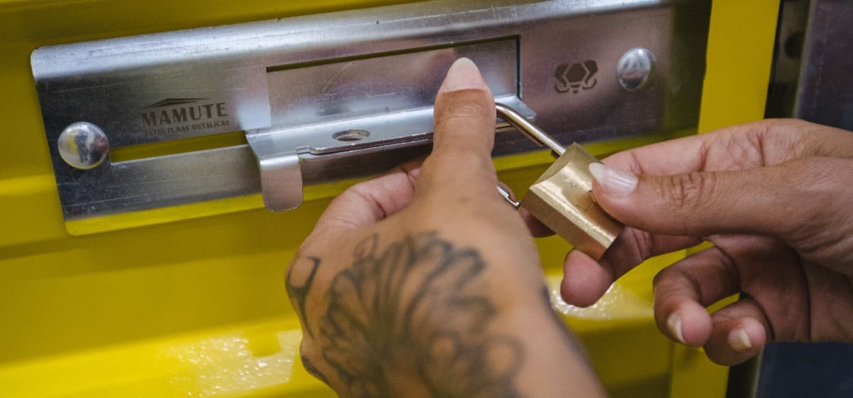 Mãos destrancando uma unidade da Unidade Ipiranga